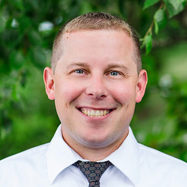 Man smiling, light hair, white shirt, tie