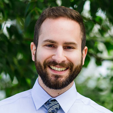 man smiling, blue shirt, tie, brown hair, beard and mustache